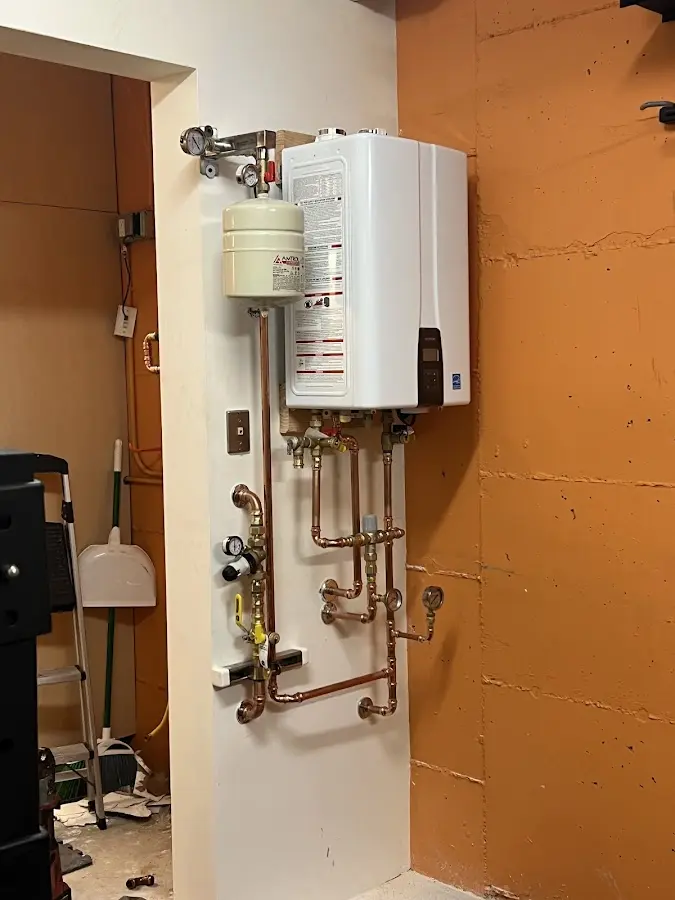 Plumbing technician inspecting water heater connections in Shady Side